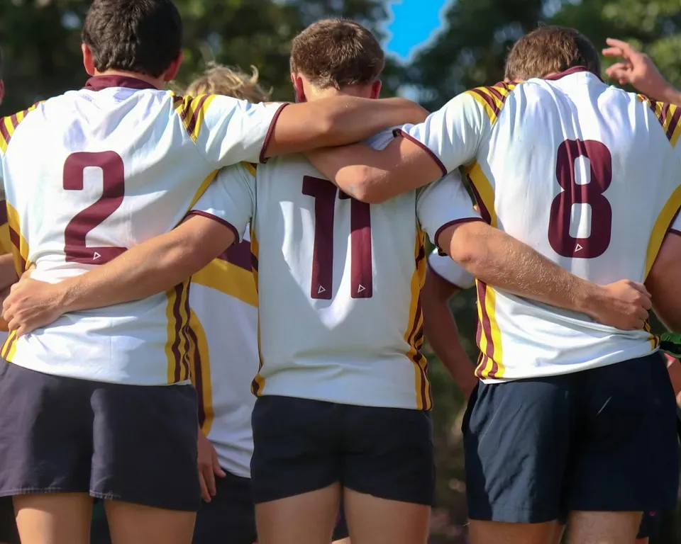 Joueurs de rugby d’un club, bras dessus bras dessous